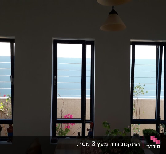 עציצים עם צמחים ירוקים ופרחים ורודים על אדן החלון